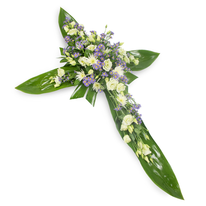 Set against a stark white field and photographed from a soft overhead angle, this floral cross expresses calm and dignity through contrast and careful placement. Broad, vivid green tropical leaves create the structural outline - their glossy planes and visible veins arranged with precision to form the cross's arms and central axis - providing a strong, natural scaffold. Crowding the centre and tracing the main lines, clusters of creamy-white lisianthus bloom in layered ruffles, their tender petals gently curling to suggest softness and consolation. Among these, small, rounded daisy-like chrysanthemums or miniature roses lend bright points of white and subtle textural variation, while slender sprays of pale lavender aster or limonium peek through, offering a cool, ethereal note that lifts the palette. Scattered finer greens act as filler, giving the floral masses breathing space and a more organic silhouette against the smooth leaf base. The lighting bathes the arrangement evenly, highlighting the subtle sheen on leaves and the delicate translucence of lisianthus petals, casting faint shadows that enhance depth without harshness. Imagining this piece in Canonbury - perhaps beside a memorial service at a local church on Upper Street or laid near a favourite bench in Canonbury Square - its mood is one of respectful remembrance and gentle solace. The scent is unobtrusive, green and faintly sweet, the textures a thoughtful interplay of waxy foliage and soft blossoms. This cross serves as a considered expression of sympathy and faith, a quiet floral testament to memory and consolation appropriate for funeral or graveside ceremonies.