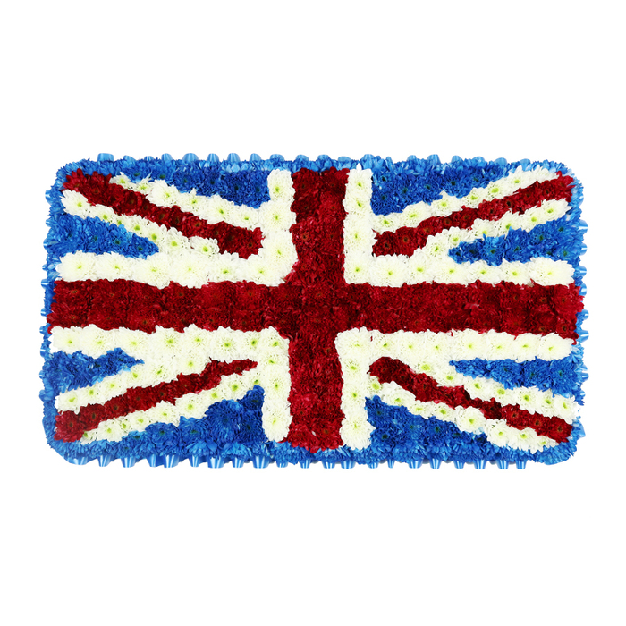 This image captures a meticulously crafted floral Union Jack, shaped as a low, rectangular funeral tribute and photographed against a clean white background to isolate its strong colours and careful detailing. The artisan florist has used countless small, densely packed flowers to recreate the national flag of the United Kingdom with remarkable precision. A deep field of blue blossoms forms the base, their tiny petals layered tightly together to create a uniform background and a neat outer border. On this sea of blue, the broad red cross of St. George dominates the centre, running vertically and horizontally in thick bands made from velvety red chrysanthemums or similar full-headed blooms. Intersecting these are the diagonal red bands of St. Patrick's Cross, slightly narrower but equally bold, stretching from corner to corner. Surrounding the red elements, sharply defined lines of white flowers act as the fimbriation, ensuring a clear separation between red and blue. Wider diagonal sweeps of white represent the cross of St. Andrew, adding both clarity and light to the design. The surface looks soft and lush, with a subtle three-dimensional quality created by the natural rise and fall of each flower. There is a quiet, solemn beauty to the piece, perfectly suited to funerals, memorials, and days of national remembrance. One can imagine this tribute being delivered by Canonbury Flowers to a local service in Islington or near Highbury Fields, chosen by a family wishing to honour a loved one's British heritage, military service, or lifelong connection to the community with a patriotic yet deeply personal final gesture.