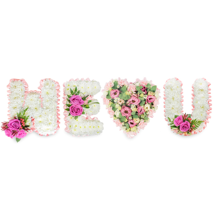 This carefully composed floral tribute spells out H, E, a heart, and U in a design that balances formality with tenderness. From the left, the H is shaped from dense white chrysanthemums whose cushion-like faces give the letter a soft, almost cloudlike texture; the edges are softly framed with a pale blush satin ribbon that folds and pleats like a ribboned keepsake. A vivid accent of two fuchsia-pink roses, small dark-red berries and fine, deep-green ferny foliage sits at the lower left of the H, adding a bright, fragrant counterpoint. The E mirrors this craftsmanship in white chrysanthemum, edged in the same blush ribbon and punctuated along its middle bar by a trio of intense fuchsia roses and glossy greenery. Replacing a literal I, the central heart is a generous, romantic shape filled with layers of soft-pink carnations and spray carnations, blush lisianthus (eustoma) or little roses, all cushioned by pale-green eucalyptus leaves that lend cool tone and a subtle, citrusy scent. The U completes the sequence with matching white chrysanthemums, blush ribbon trim and a small cluster of fuchsia roses at its inner curve to echo the other accents. Bathed in neutral light and photographed on a brilliant white background, the arrangement reads as a solemn yet loving message - suitable for a celebration of life at a chapel near Essex Road or a private remembrance on St Paul's Road - conveying purity, gratitude and the quiet comfort of memory.