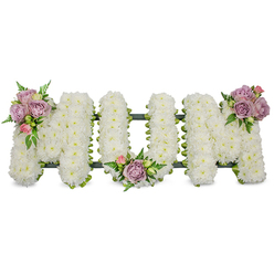 Delicately constructed to spell the word MUM in upright capital letters, this sympathy piece is entirely covered with tiny, crisp-white chrysanthemums or similar spray blooms, each flower placed close to its neighbour to form a seamless, plush surface. The white palette reads as calm and reverent, while three modest clusters of muted colour give the arrangement its intimate highlights: a grouping of soft lavender roses and a single pale pink bud on the upper left arm of the first M, a similar pairing tucked into the U's central dip, and a final pastel cluster set on the upper right arm of the last M. These roses - varying from tight bud to softly unfurled petals - bring a faint, honeyed rose scent and a tactile contrast to the cushiony chrysanthemums. Luminous green foliage, including narrow fern fronds and fresh leaf sprays, weaves through the letters and frames the pastel accents, adding movement and definition. A dark green support structure, possibly wrapped in ribbon or moss, is visible as a shadowed outline along the base, ensuring the letters remain perfectly formed for standing display. Bathed in soft, even light, the tribute communicates comfort and respectful remembrance; it is intended for use at a funeral service, memorial, or graveside. As a local Canonbury florist might arrange for families around Essex Road, Upper Street, or Canonbury Square, this piece can be prepared and arranged with care for delivery to nearby chapels and churches.