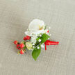 Resting on a pale beige woven fabric, this boutonniere centres on a pristine white phalaenopsis orchid whose creamy petals open in smooth, symmetrical curves to reveal a gentle yellow-orange throat. Surrounding it, fine sprays of gypsophila provide a frothy, ethereal texture-tiny white blossoms like a soft snowfall around the focal bloom. Bright clusters of red hypericum berries punctuate the design, their polished skins catching light and adding a joyful, almost festive counterpoint to the serene orchid. Slim, pale-green buds suggest freshness and growth, while broad, glossy green leaves, likely salal, cradle the cluster and introduce a grounding, verdant frame. The stems are neatly bound with a deep red satin ribbon knotted with care, the short tail extending to the right, lending a polished, personal finish.

A favourite at Canonbury Flowers, this style is often chosen for intimate weddings at Canonbury Square or for ceremonies near St. Paul's Road and the New River Walk. As a local florist I note how the neutral linen backdrop highlights the natural textures and the subtle play of light on each element. The boutonniere feels sophisticated yet approachable-perfect for a groom or guest wanting a touch of refined colour that reflects Canonbury's leafy charm and understated elegance.