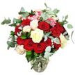 This image shows a luxurious rose bouquet arranged with the kind of care you might expect from Canonbury Flowers for a special delivery across N1. A clear glass vase, its base gently rounded and its neck slightly narrower, holds a generous cluster of stems in clean water, giving a glimpse of the careful spiralling technique used to build the design. Rising from the vase, numerous red and scarlet roses form the heart of the bouquet, their velvety petals layered in lush swirls, some blossoms fully open in expressive, romantic rosettes, others still curled in tight buds that hint at blooms yet to unfold. Interlaced with these rich tones are elegant ivory and creamy white roses, and a few white roses softened with pale pink at their tips, which together bring brightness and a sense of calm to the arrangement. Here and there, small tufts of bright pink filler flowers add a gentle, lively accent, creating tiny pockets of texture that contrast with the smoother rose petals. Encircling the whole display, blue-green eucalyptus leaves with their recognizable rounded shapes arc outward and upward, mingling with dark glossy foliage and silvery-green sprigs to build a full, rounded silhouette. The eucalyptus suggests a fresh, slightly citrusy fragrance, the kind that would fill a hallway or living room in Canonbury or along nearby St Paul's Road when the bouquet is first set down. The white background removes any distractions, focusing attention entirely on the interplay of reds, whites, and greens. The result is a lush yet polished arrangement that conveys affection, devotion, and quiet luxury-perfect for marking milestones, from Valentine's Day dinners at home to meaningful anniversaries.