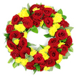 A carefully arranged circular funeral wreath filled with red roses and yellow chrysanthemums sits against a crisp white background, its elegant design evoking the quiet dignity of a Canonbury memorial service. The wreath forms a complete, symmetrical ring with a central opening, each bloom placed so that the circle appears full, balanced, and continuous. Deep red roses dominate the composition, set close together so that their velvety petals almost touch, forming a rich, romantic band of colour. The roses are fully open, showing gently spiralling centres and outer petals that deepen into darker crimson and near-burgundy tones at the edges. Between these roses, clusters of small, sunny yellow chrysanthemums nestle in a regular rhythm, their feathery petals fanning out to create soft, rounded shapes that brighten the wreath and add texture. Supporting this interplay of red and yellow is a base of varied green foliage, likely a mix of salal and eucalyptus. The leaves peek out from behind the flowers with different textures and tones - some broad and glossy dark green, others slender and silvery green - adding freshness and a natural, garden-inspired feel similar to the greenery of nearby Canonbury gardens and tree-lined streets. The lighting is bright and even, emphasising the vivid contrast between the colours and revealing delicate shadows in the petals and leaves. The overall impression is of a high-quality, thoughtfully crafted floral tribute, ideal for a funeral or graveside farewell, conveying enduring love, remembrance, and a gentle hint of hope through its warm, harmonious palette.