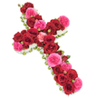 A beautifully structured floral cross rests against a stark white background, its colours and textures carefully balanced to create a serene and respectful funeral tribute. The centre of the cross is richly packed with large, velvety deep red roses, each one open to its fullest, forming a luxuriant blanket of petals along both the vertical and horizontal beams. Their dark, wine-red tone suggests deep affection, commitment, and a lasting connection that extends beyond goodbye. Interspersed between these crimson blooms are vivid fuchsia pink roses or similar full-petalled varieties, whose lighter, more playful hue brings a gentle warmth and a quiet hopefulness to the design. Smaller rosebuds, mirroring the same red and pink palette, punctuate the arrangement, providing delicate points of interest and hinting at memories that continue to unfold over time. The entire silhouette of the cross is neatly edged with a slim border of tiny white flowers, perhaps spray chrysanthemums, gypsophila, or miniature carnations, which create a soft, cloudlike frame. These white blooms highlight and refine the cross's outline while suggesting purity, peace, and the comfort of spiritual light. Subtle touches of fresh greenery, woven just beneath the flowers along the perimeter, add definition and a natural freshness without breaking the disciplined lines of the design. The lighting is even and calm, allowing every petal and texture to be clearly discerned, with no distractions from the simple background. This floral cross is the kind of handcrafted memorial piece that families around Canonbury, Mildmay, and along St Paul's Road might choose to accompany a funeral service or graveside farewell, offering a graceful expression of faith, love, and remembrance.