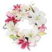 A radiant, full-circle floral wreath celebrates both life and legacy, as prepared by experienced Canonbury florists for memorial occasions across the area. Majestic white Oriental lilies dominate the design, spreading their star-shaped petals with a tranquil elegance, each blossom hinting at peace, renewal, and a gentle farewell. Vivid fuchsia-pink lilies are thoughtfully woven throughout, their electric magenta shades and darkly speckled centers infusing the wreath with graceful warmth and emotional depth. Scattered among these larger flowers, clusters of blush pink and creamy white roses-in varying states of bloom-add layers of delicate texture, fragrance, and quiet grace, reminiscent of a walk through local Canonbury rose gardens in late spring. Sprays of muted green foliage-eucalyptus and lily leaves-peek from beneath the blooms, lending natural movement and subtle structure, much like the soft breezes along St. Paul's Road. The arrangement's circular, unbroken form becomes a symbol of eternity, remembrance, and loving tribute, making it perfectly suited for funerals, condolence gestures, and celebration of life services. Set against a clean white backdrop, each bloom and leaf stands out in crisp relief, capturing the sensitive artistry of Canonbury's local florists and inviting both comfort and reflection in moments of loss. This wreath's classic palette and lush textures make it a poignant expression of sympathy, crafted with heartfelt care and rooted in the spirit of the community.