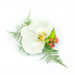 There is a quiet, radiant elegance in this wedding corsage: a single pristine white Phalaenopsis orchid rests at the centre, its broad, satiny petals unfolding with a soft, waxy sheen that catches the light against a crisp white background. The orchid's throat reveals a gentle wash of yellow and gold with faint brown speckling, giving the bloom a warm, intimate core. Wisps of fine asparagus fern fan out like tulle, feathery and pale-green, framing the blossom with a whisper of movement as if softened by an early-morning breeze. Beside the orchid, clusters of glossy, reddish-pink hypericum berries add a jewel-like pop of colour and an organic counterpoint to the calm white bloom, while a compact, lime-green chrysanthemum or small mum sits tucked beneath, offering bright, zesty contrast and tactile texture. Composed asymmetrically but balanced-leftwards sweep of fern, rightward cluster of berries-the piece reads as small wearable sculpture, intended to be pinned to a lapel or slipped into a wrist cuff for a wedding, prom, or formal celebration. The lighting is clean and bright, rendering each surface and vein visible: the orchid's silky curve, the fern's delicate filaments, the berries' glossy skins and the chrysanthemum's tight, almost succulent clusters. As a florist working in Canonbury, I think of this corsage paired with the soft stone façades around Canonbury Square or the understated greenery along New River Walk-a refined accent that feels both modern and timeless, carrying a quiet joy appropriate for vows, announcements, or a special evening in Islington.